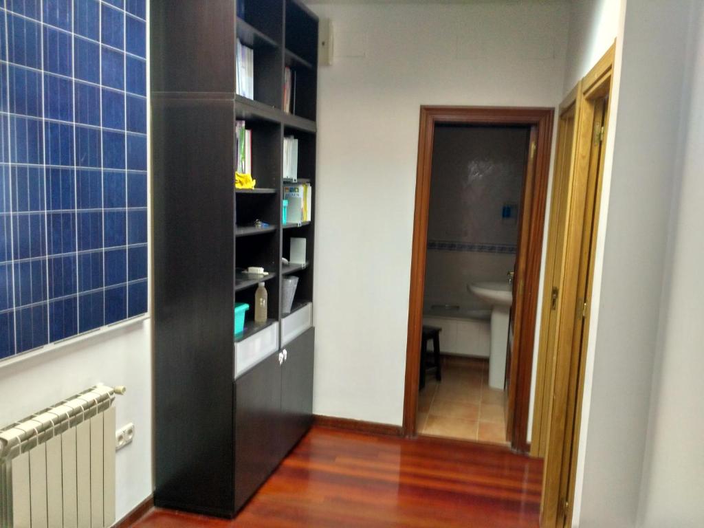 a hallway with a black book shelf and a bathroom at Fogar de Breogan in Santiago de Compostela