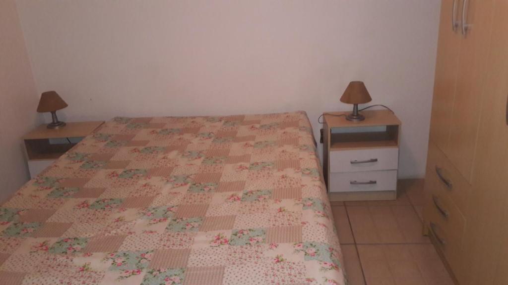 a bedroom with a bed and two night stands at Beira mar Mariluz in Imbé