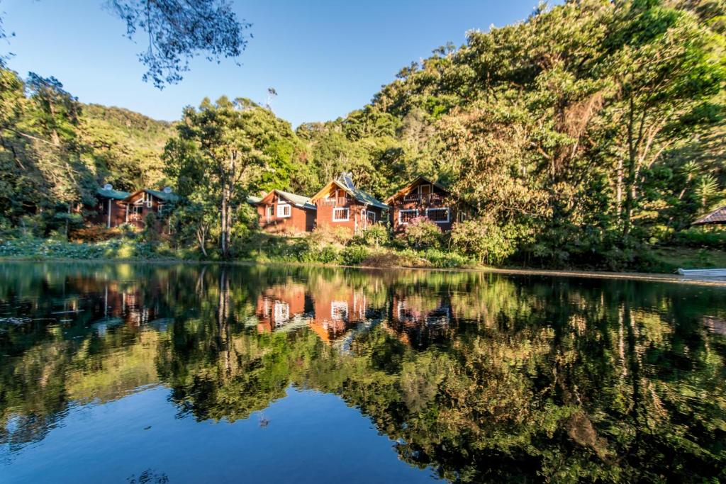 un reflejo de las casas en el agua de un lago en Sueños del Bosque Lodge, en San Gerardo de Dota
