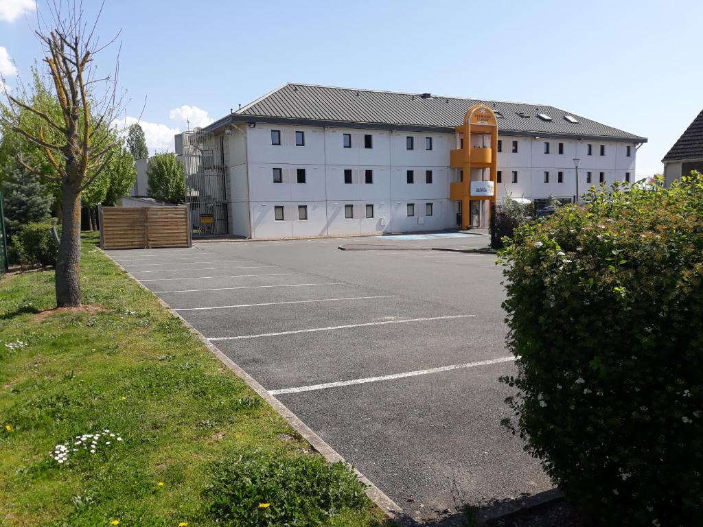 an empty parking lot in front of a building at Premiere Classe Orleans Ouest - La Chapelle St Mesmin in La Chapelle-Saint-Mesmin