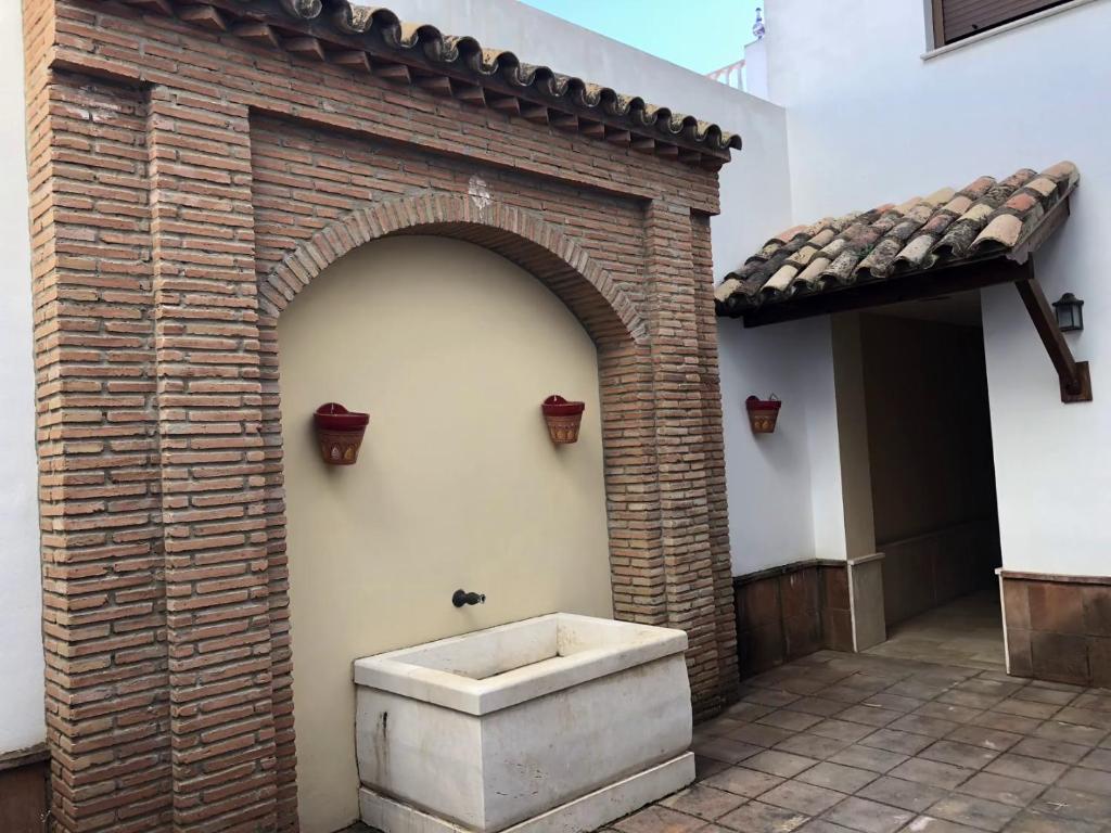サンルーカル・デ・バラメダにあるSanlucar Iの中庭のバスタブ付きのレンガ壁