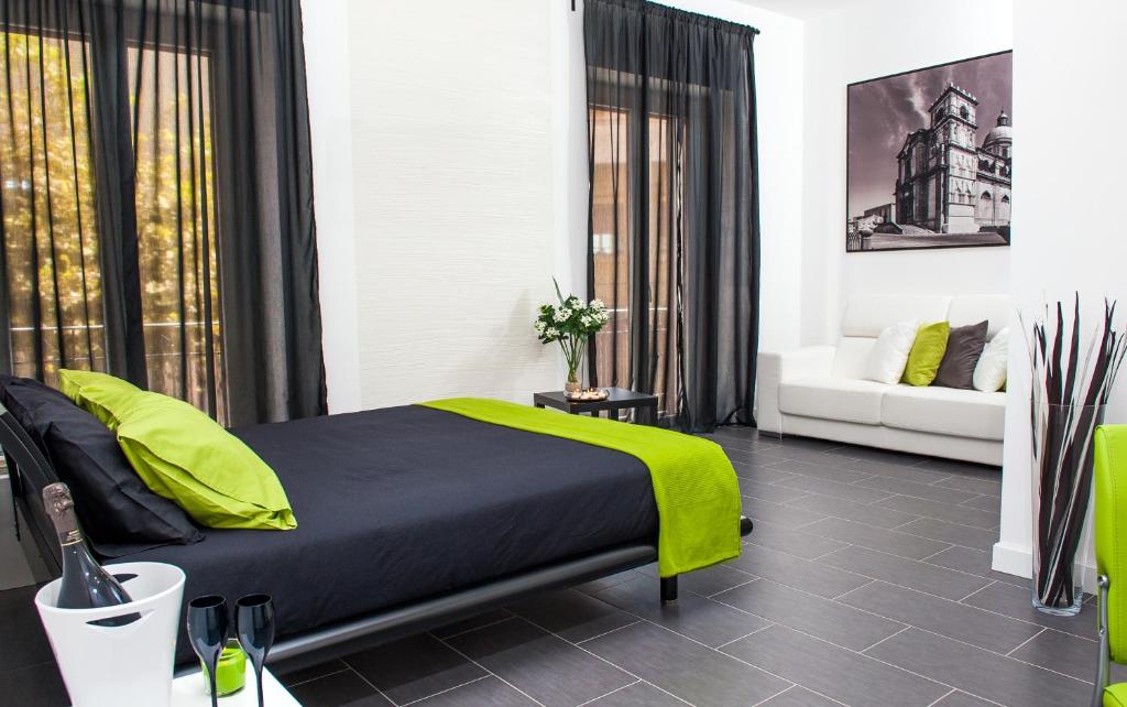 a bedroom with a bed with a green blanket at B&B Diana in Piazza Armerina