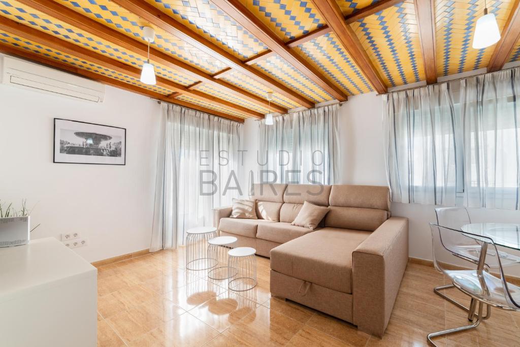 ein Wohnzimmer mit einem Sofa und einem Tisch in der Unterkunft Ático Plata in Cádiz