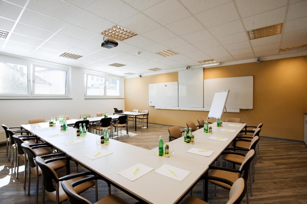 a conference room with tables and chairs and a podium at Hotel City in Villach