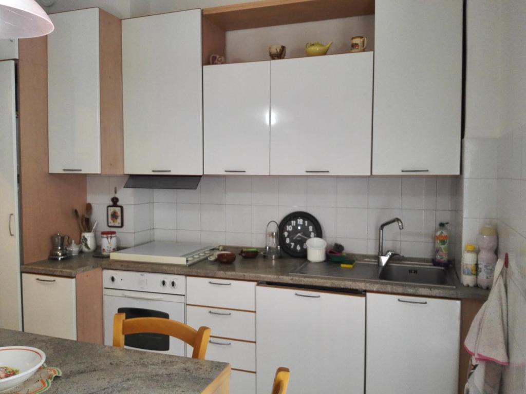 una cucina con armadi bianchi e piano di lavoro di Interno3 ad Ancona