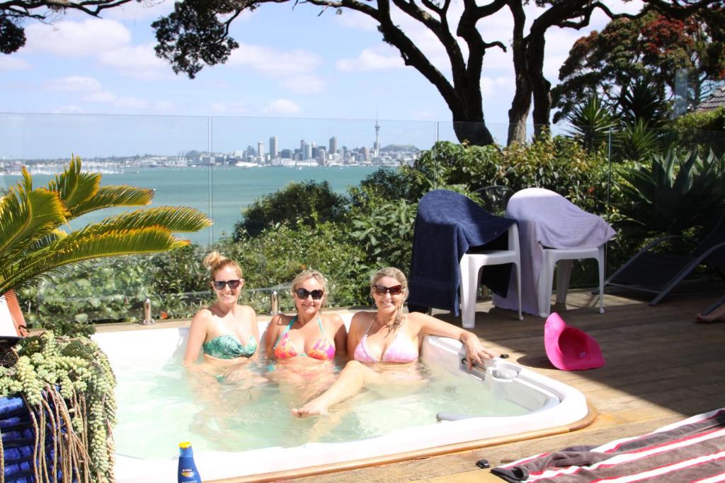 3 Frauen sitzen in einem Pool in der Unterkunft Sea view guest house in Auckland