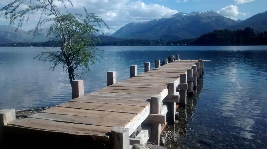 a dock on a lake with a tree on it at Casa de campo con costa de lago in San Carlos de Bariloche