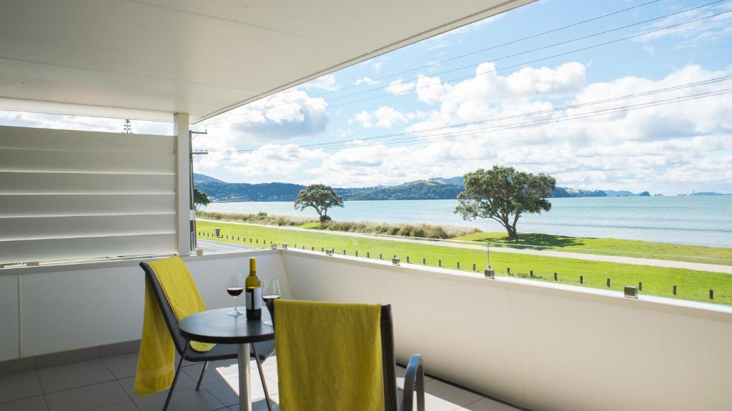 懷蒂昂格的住宿－大洋汽車旅館，阳台配有桌椅,享有水景。