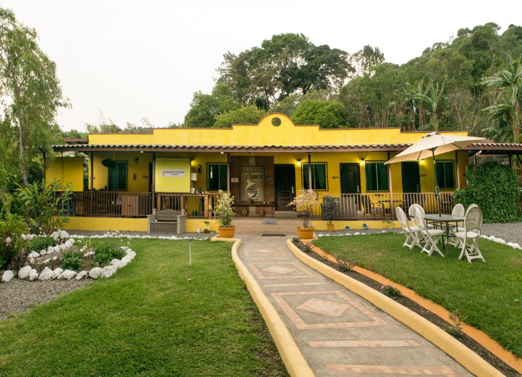 a yellow house with a table and chairs in the yard at Agaseke Lodge Boquete in Boquete