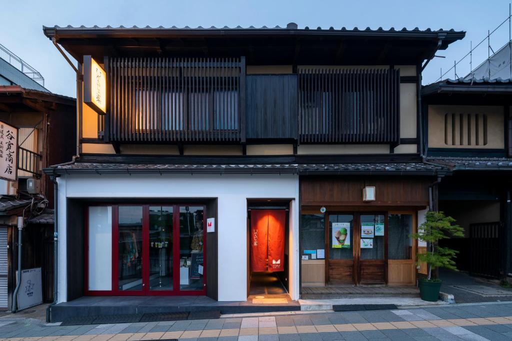 a building with a red door on a street at Hinaya Gojo in Kyoto
