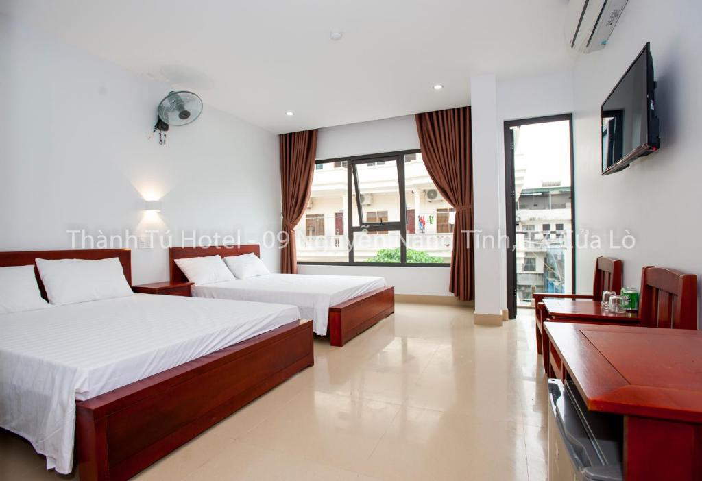 Habitación de hotel con 2 camas y TV en Thanh Tu Hotel, en Cửa Lô