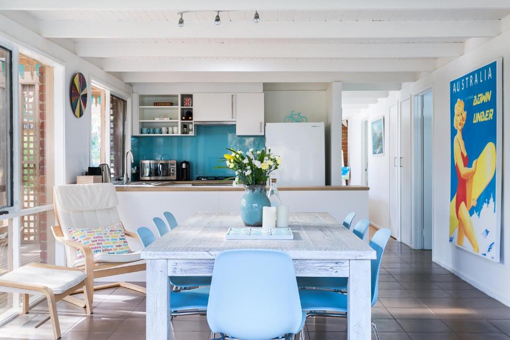 a kitchen with a table and blue chairs at Sandy's @ Rye in Rye