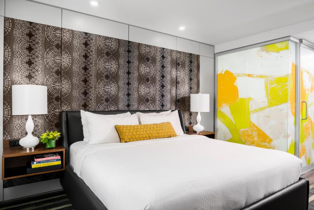 a bedroom with a white bed and a yellow pillow at Hotel Arts in Calgary