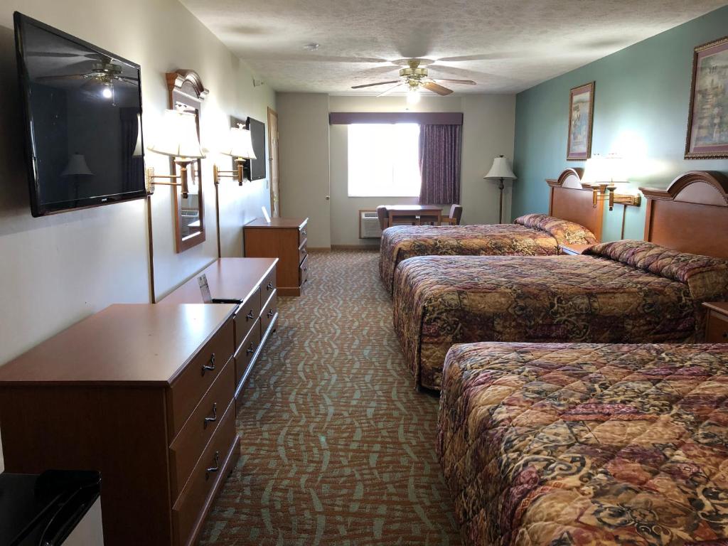 a hotel room with two beds and a television at Countryside Suites Omaha in Omaha