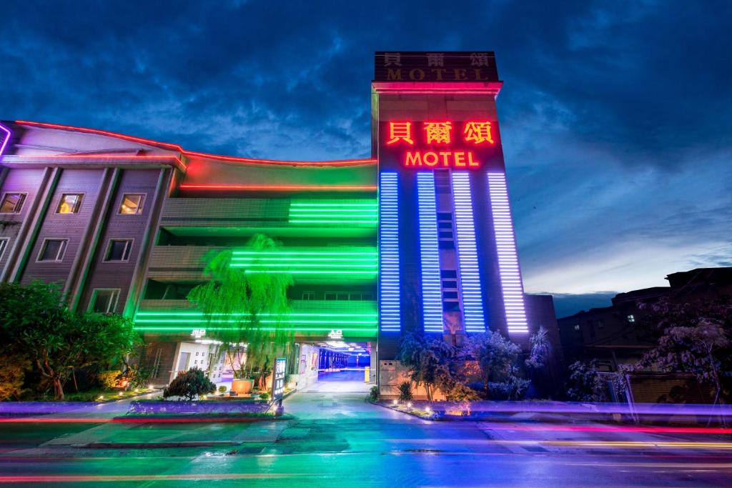 a hotel with a neon sign in front of it at Belle Song Motel in Shulin