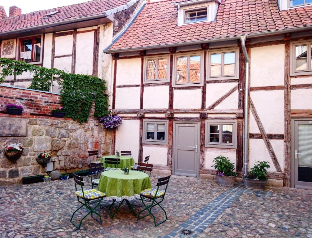 einen Innenhof eines Hauses mit einem Tisch und Stühlen in der Unterkunft Hotel garni Tilia in Quedlinburg