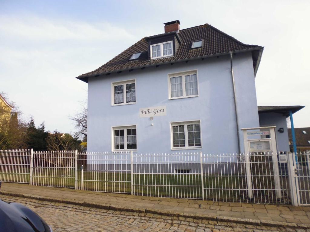 uma casa branca com uma cerca à frente. em FeWo in der Villa Gora, in Bergen auf Rügen em Bergen auf Rügen