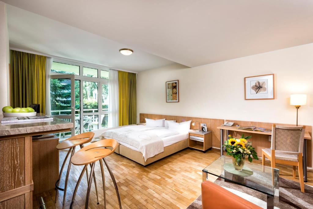 um quarto de hotel com uma cama, uma mesa e cadeiras em Westlife Apart Hotel Berlin em Berlim