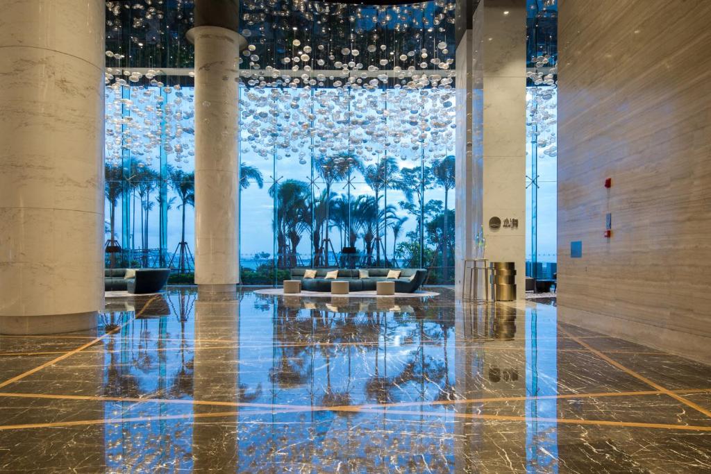 a lobby with a large window with palm trees at Fliport Wutong Hotel-Free Welcome Fruit & Near Exhibition Center in Xiamen