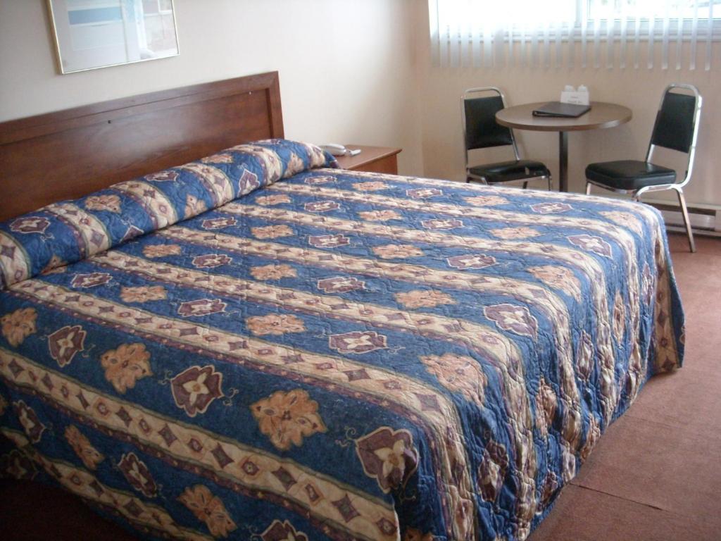 Tempat tidur dalam kamar di Grand Motel Saint-Hubert