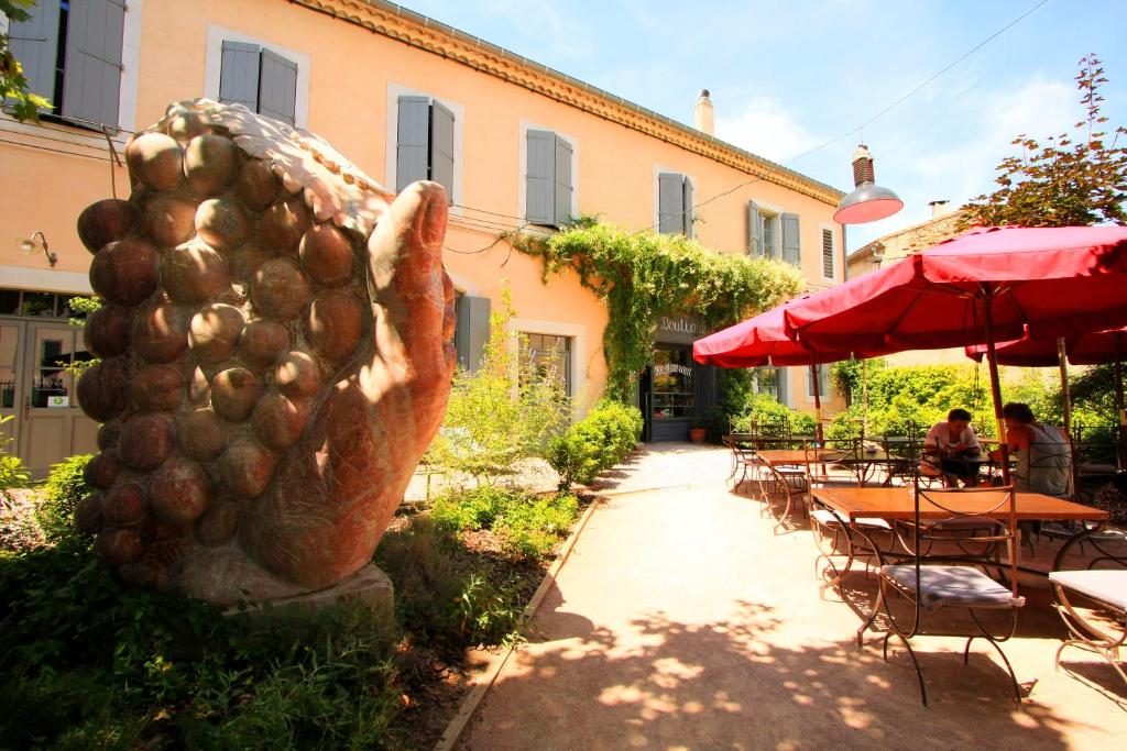 una estatua de un montón de patatas al lado de un patio en Logis Hotel - Restaurant La Marbrerie, en Caunes-Minervois