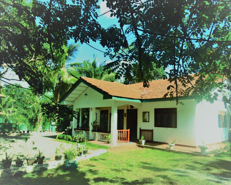 een klein wit huis met een rood dak bij Green Herbal Ayurvedic Eco-Lodge in Galle