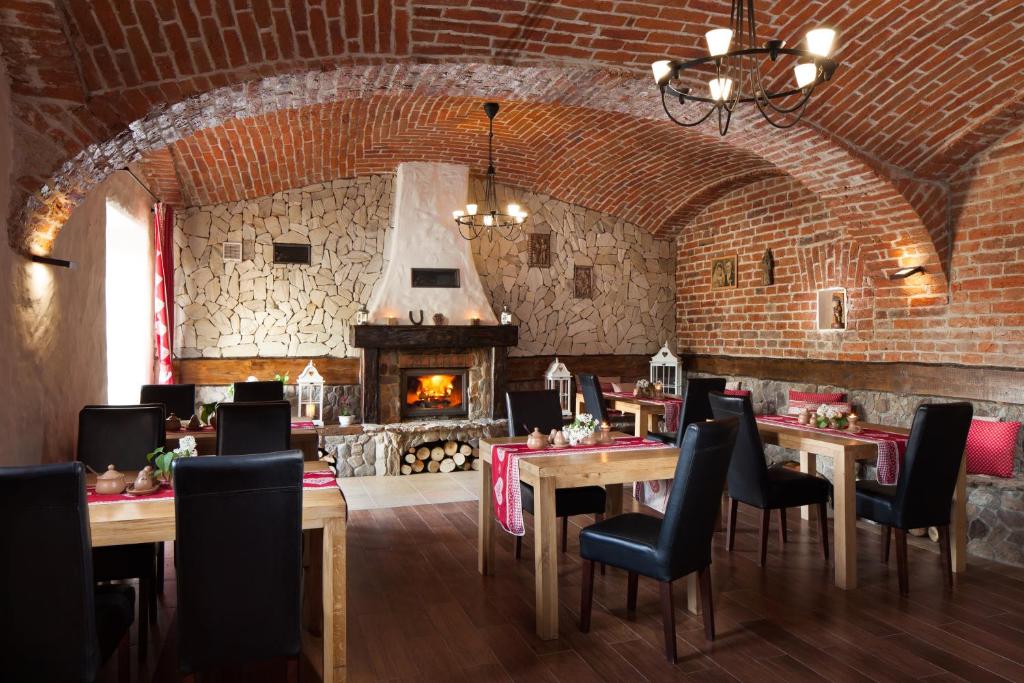 restauracja ze stołami i krzesłami oraz kominkiem w obiekcie Gospodarstwo Agroturystyczne Kowalowe Wzgórze w Polanicy Zdroju