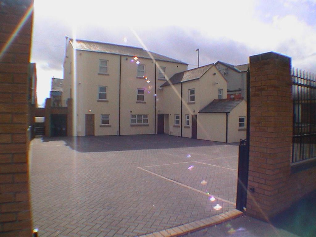 a building with a basketball court in a parking lot at Earle House Serviced Apartments in Crewe