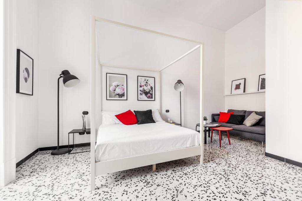 una camera da letto con un letto bianco e un grande specchio di mrg home holiday a Sorrento
