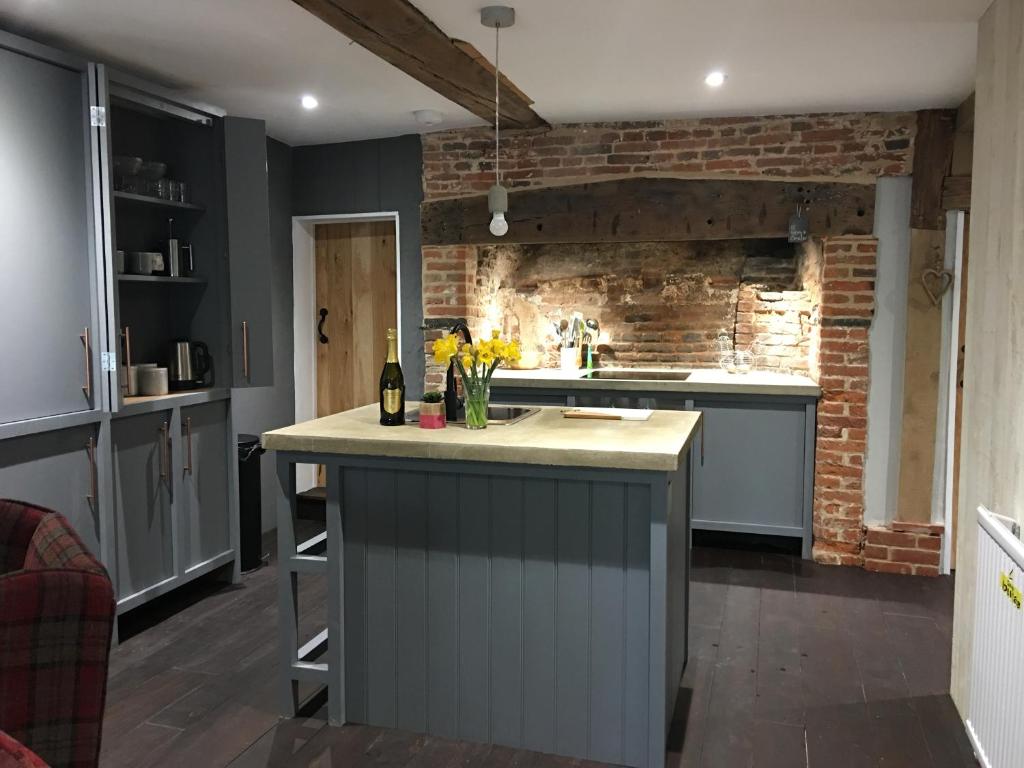a kitchen with a counter and a brick wall at Square House Bildeston High street in Ipswich