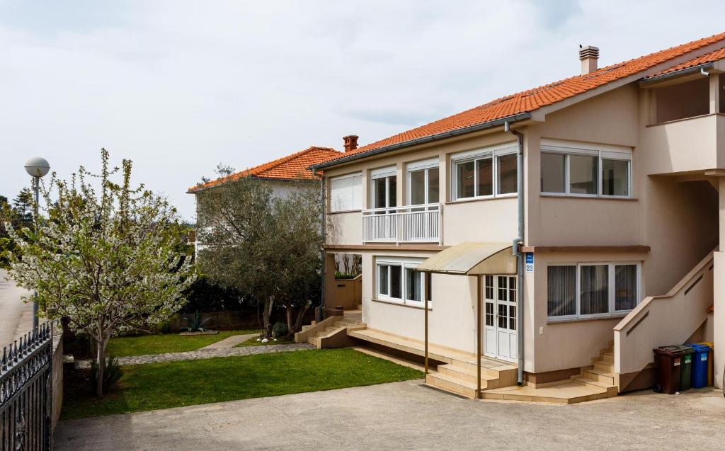 una casa blanca con una puerta y un patio en Apartments Jura, en Krk