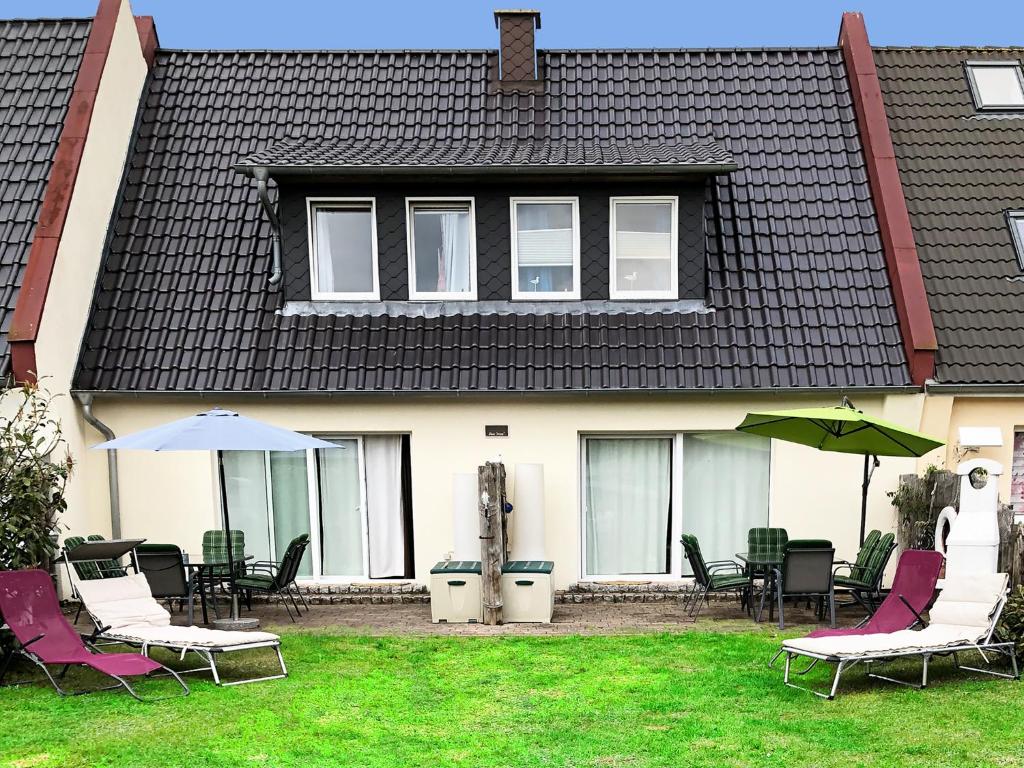 a house with chairs and umbrellas in the yard at Haus Pruchten in Pruchten