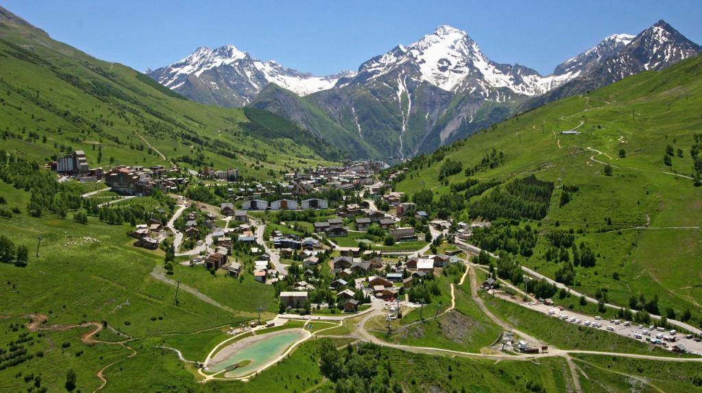 uma aldeia num vale com montanhas ao fundo em Le Montana em Les Deux Alpes