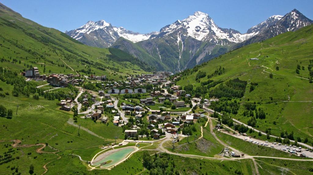 a village in a valley with mountains in the background at Le Montana in Les Deux Alpes