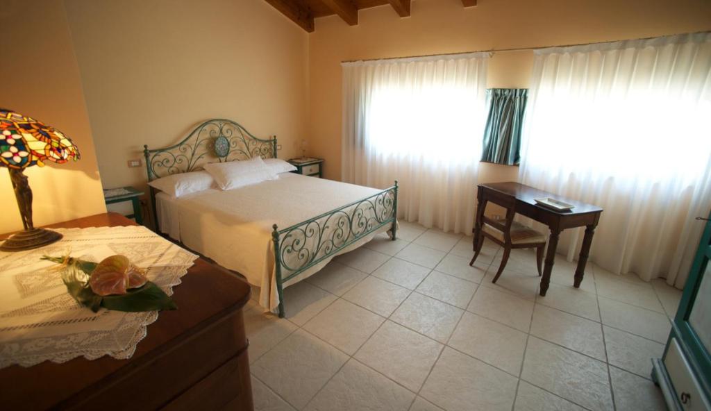 1 dormitorio con cama, escritorio y ventana en I Caloseni en Caldiero