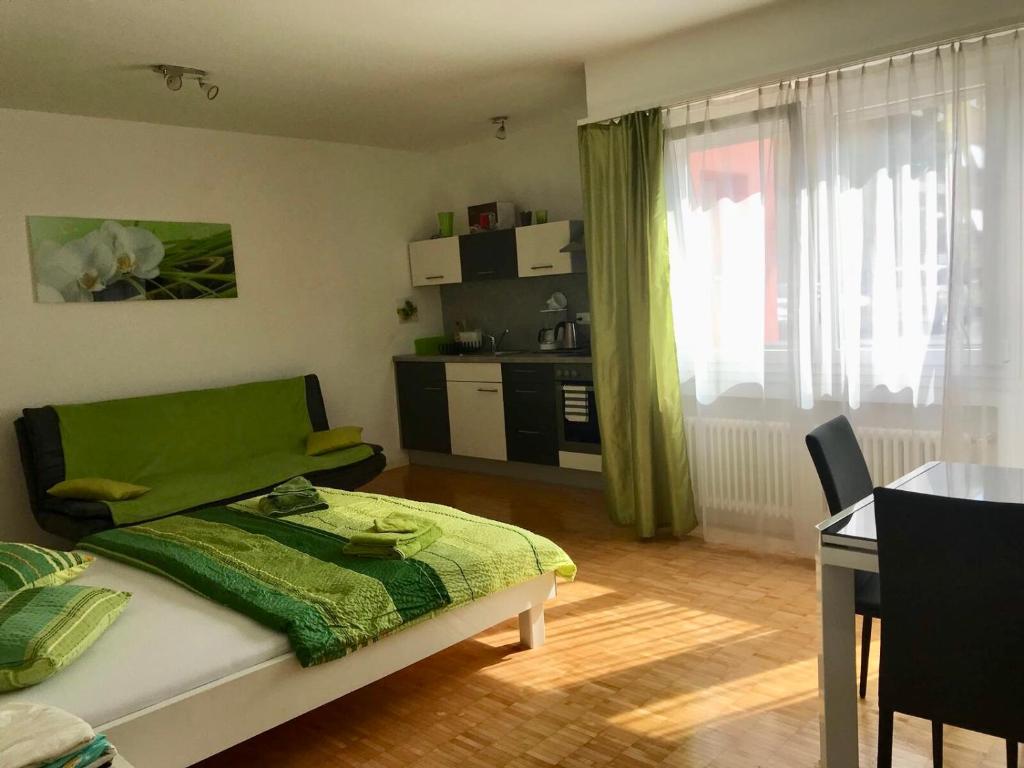 ein Schlafzimmer mit einem Bett und einem Tisch sowie eine Küche in der Unterkunft Apartment al Lido Ascona in Ascona