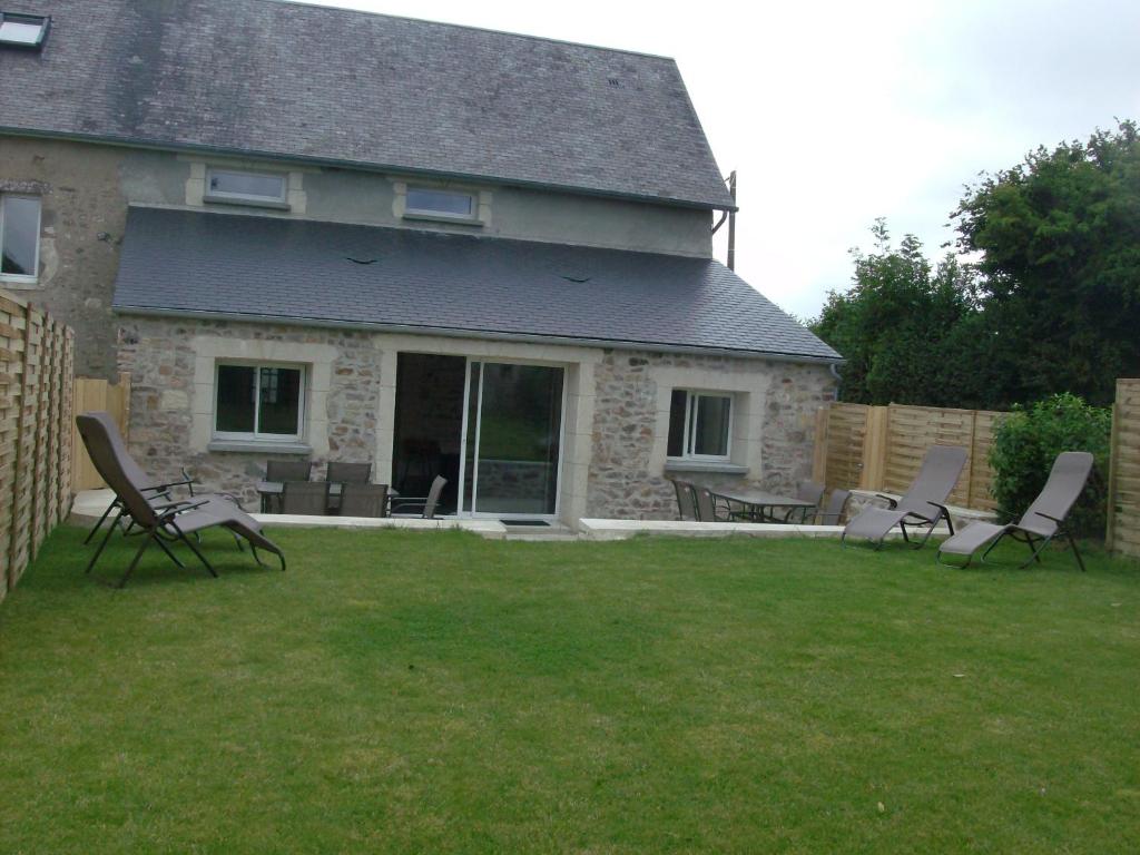 een groep stoelen in de tuin van een huis bij Gite équestre en Normandie Haras de Sainte Colombe in Sainte-Colombe