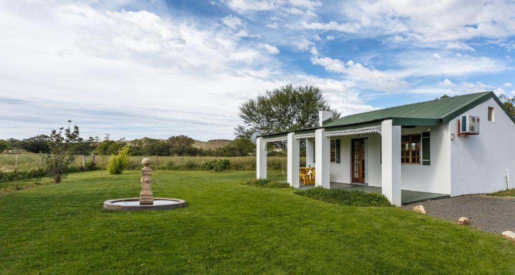 a small white house with a green roof at The Farmers Cottage Bethulie in Bethulie