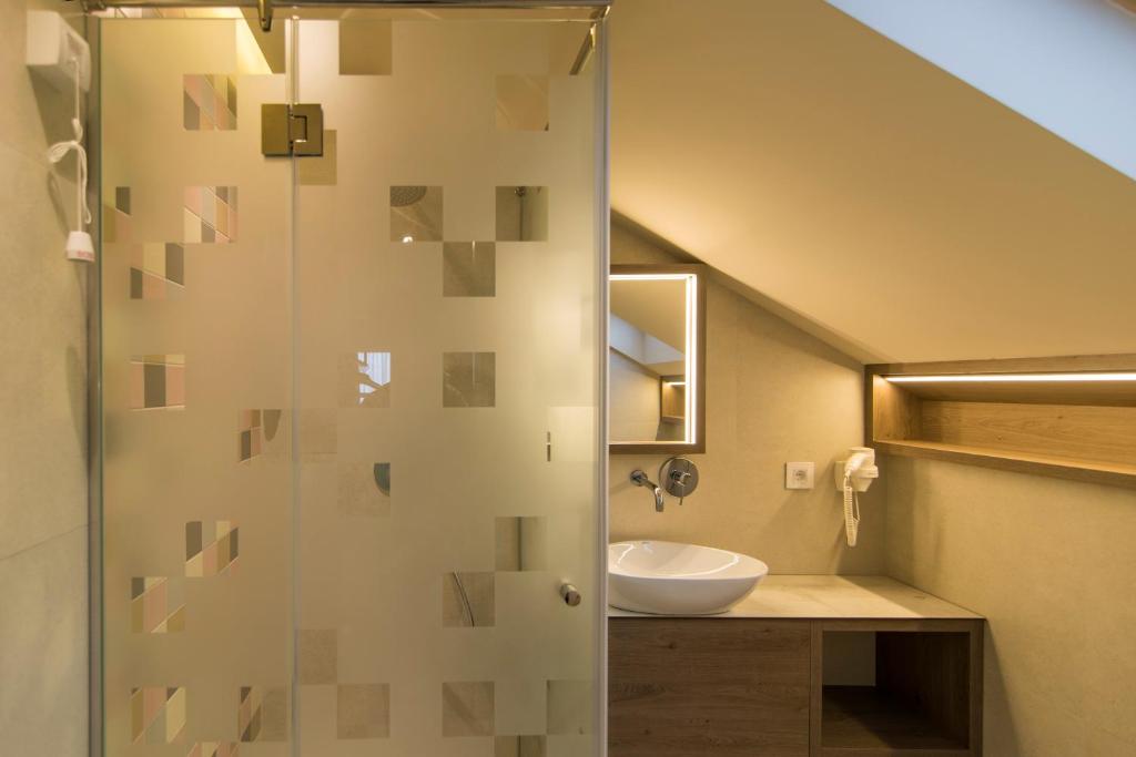 bagno con doccia in vetro e lavandino di Garni Hotel D10 a Belgrado