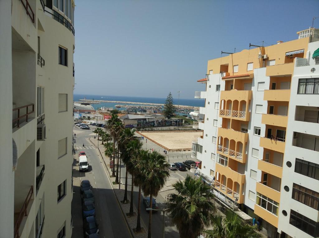 a city street with palm trees and buildings at Austral Apartment in Quarteira