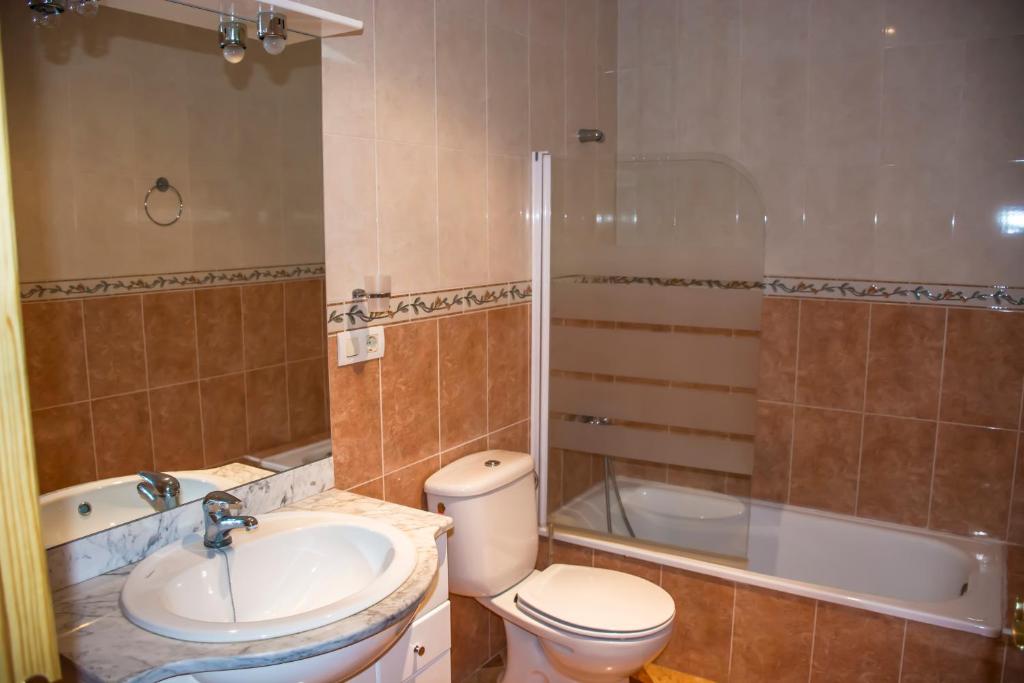 a bathroom with a toilet and a sink and a tub at Casa Rural Maria Belen in Ruidera