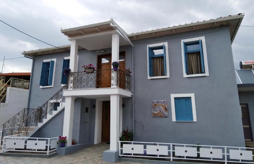 une maison bleue avec un balcon dans une rue dans l'établissement Alexanderland, à Pélla