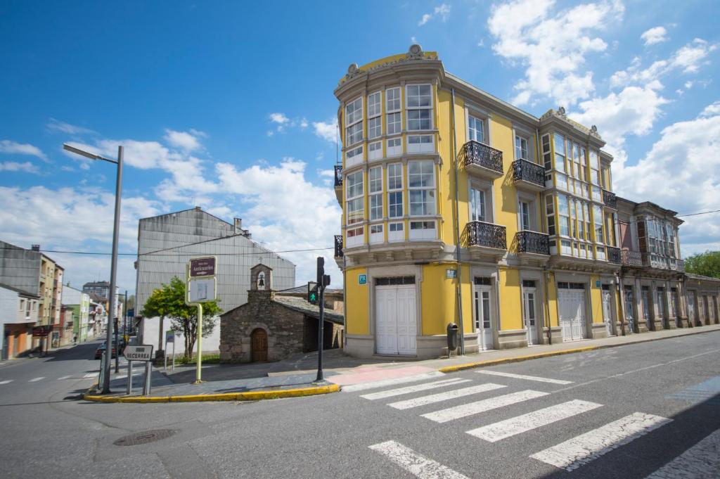 um edifício amarelo na esquina de uma rua em La Posada de La Casona de Sarria em Sarria