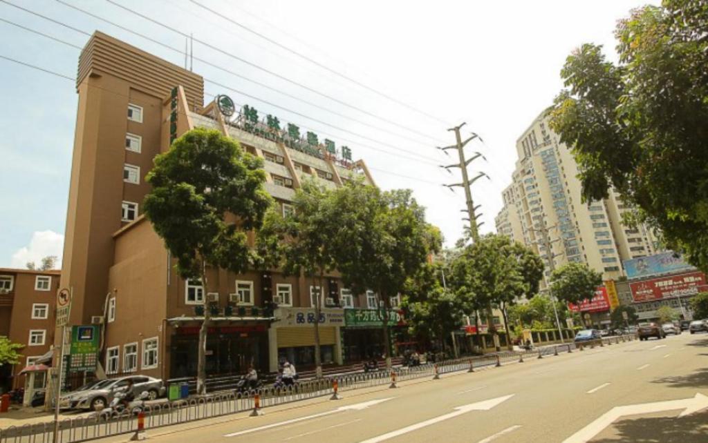 una calle de la ciudad con edificios altos en una calle de la ciudad en GreenTree Inn Hainan Haikou Guomao Business Hotel en Haikou