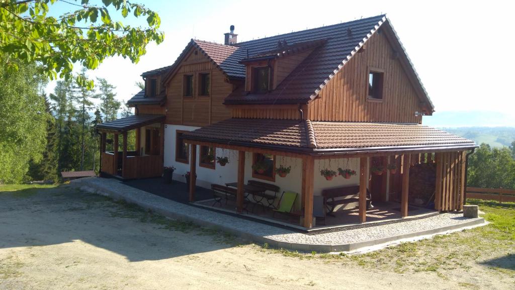 una grande casa in legno con portico di Widokowa Osada a Międzylesie