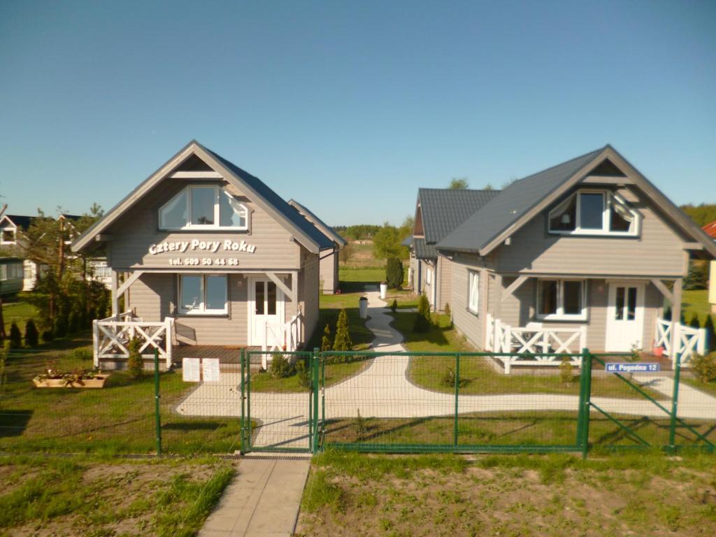 a house with a fence in front of it at Cztery Pory Roku in Trzęsacz