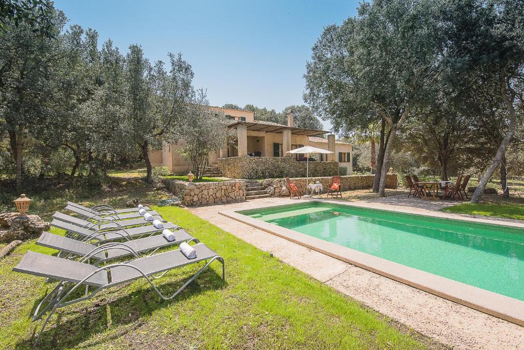 einen Pool mit Liegestühlen neben einem Haus in der Unterkunft Mirador - idyllic countryside villa near Arta in Artá