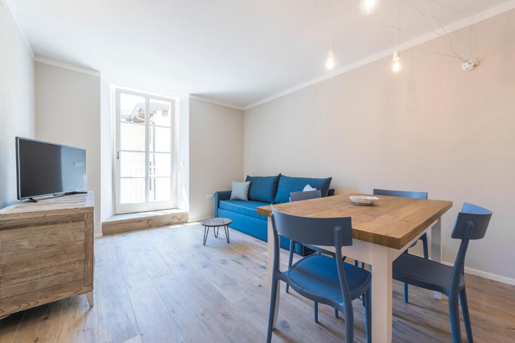 salon ze stołem i niebieską kanapą w obiekcie Casa Tonetta Luxury Apartments w Arco