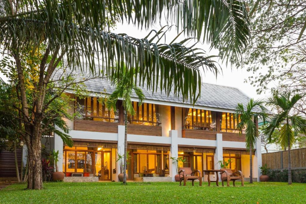 a house with a palm tree in front of it at Baan Tye Wang Guesthouse in Phra Nakhon Si Ayutthaya