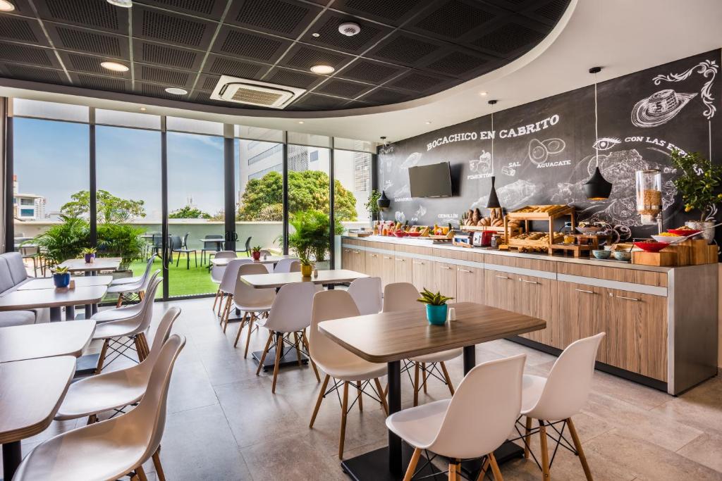 a restaurant with tables and chairs and a counter at ibis Barranquilla in Barranquilla